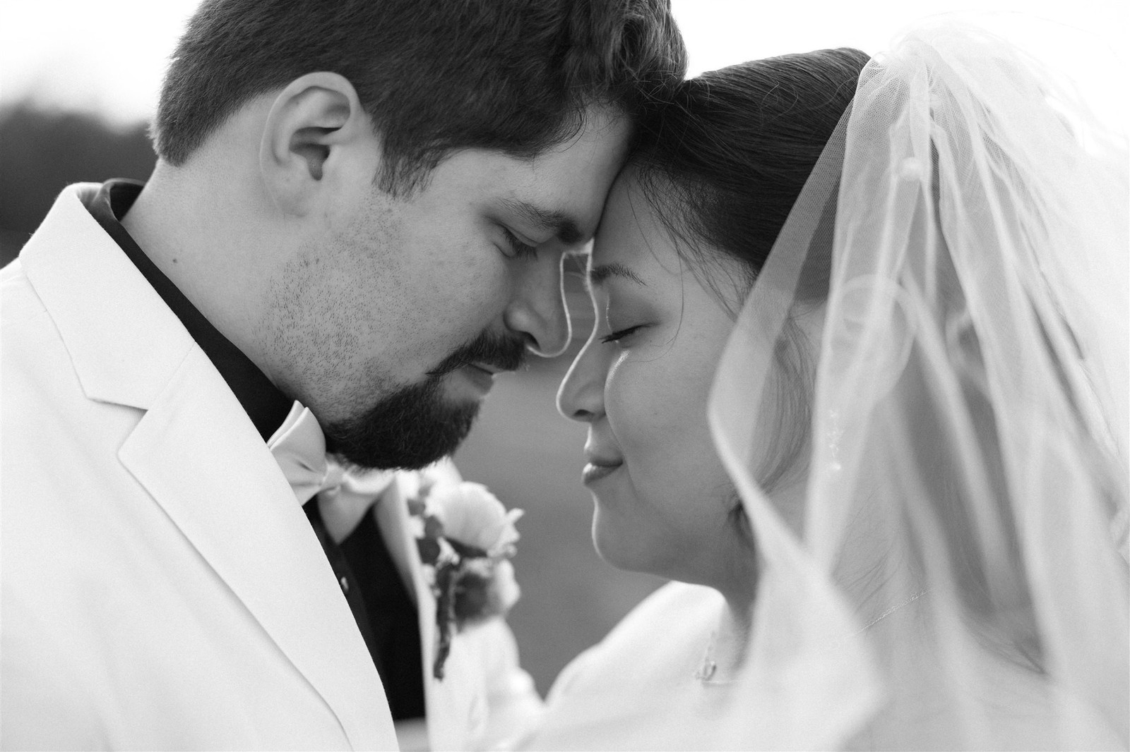 Bride and groom forehead to forehead in a tender moment.