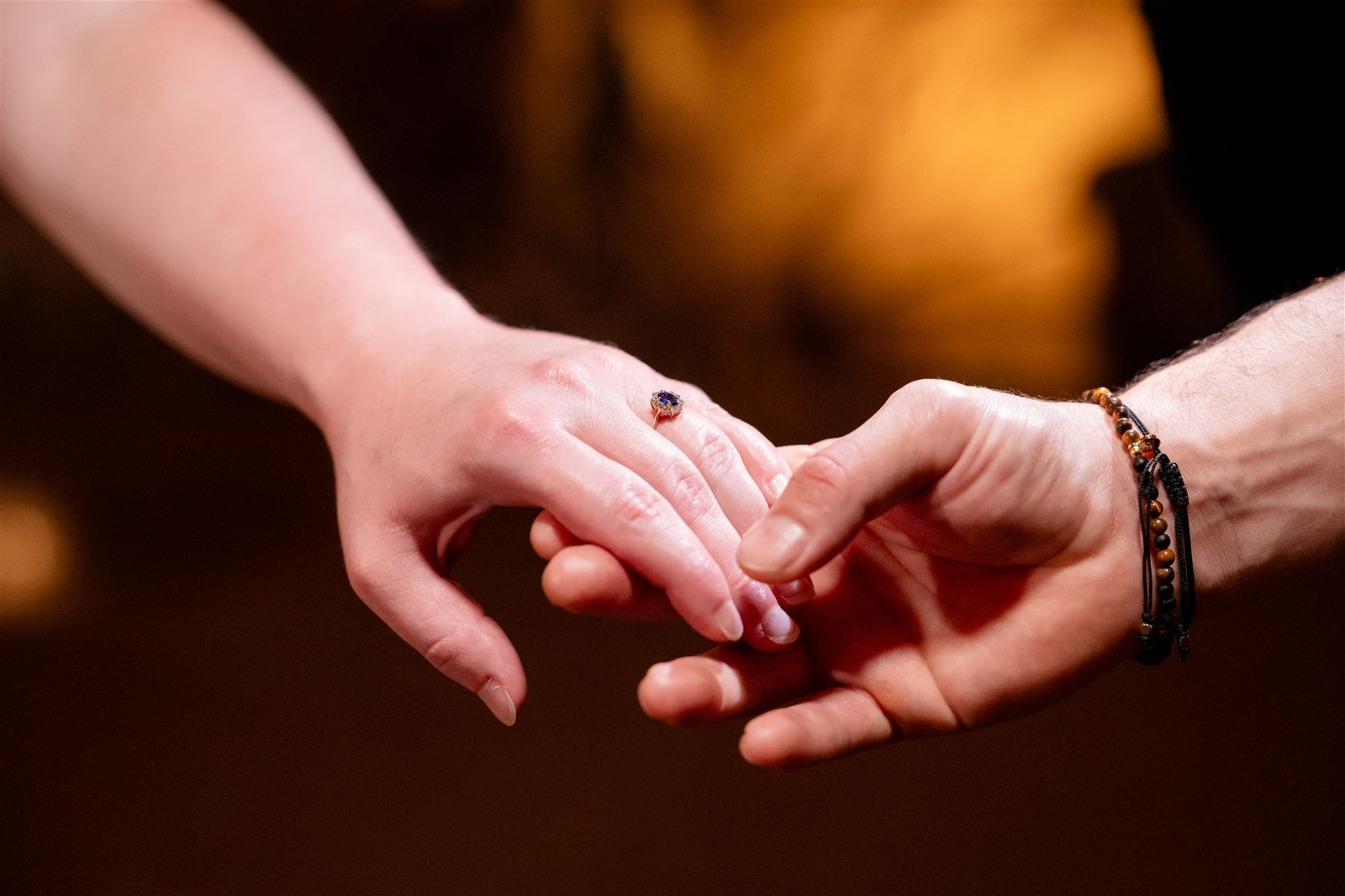 Couple holding hands, engagement ring visible. Luray Caverns wedding photography.