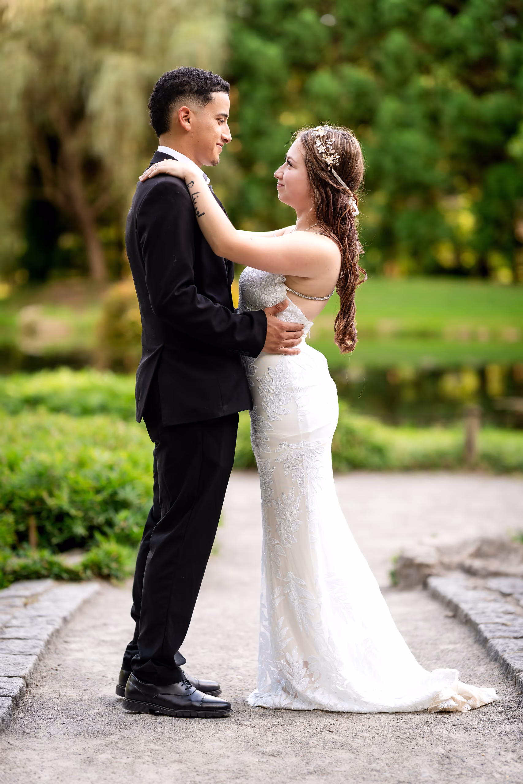 Bride and groom embracing in a garden setting, wedding day.