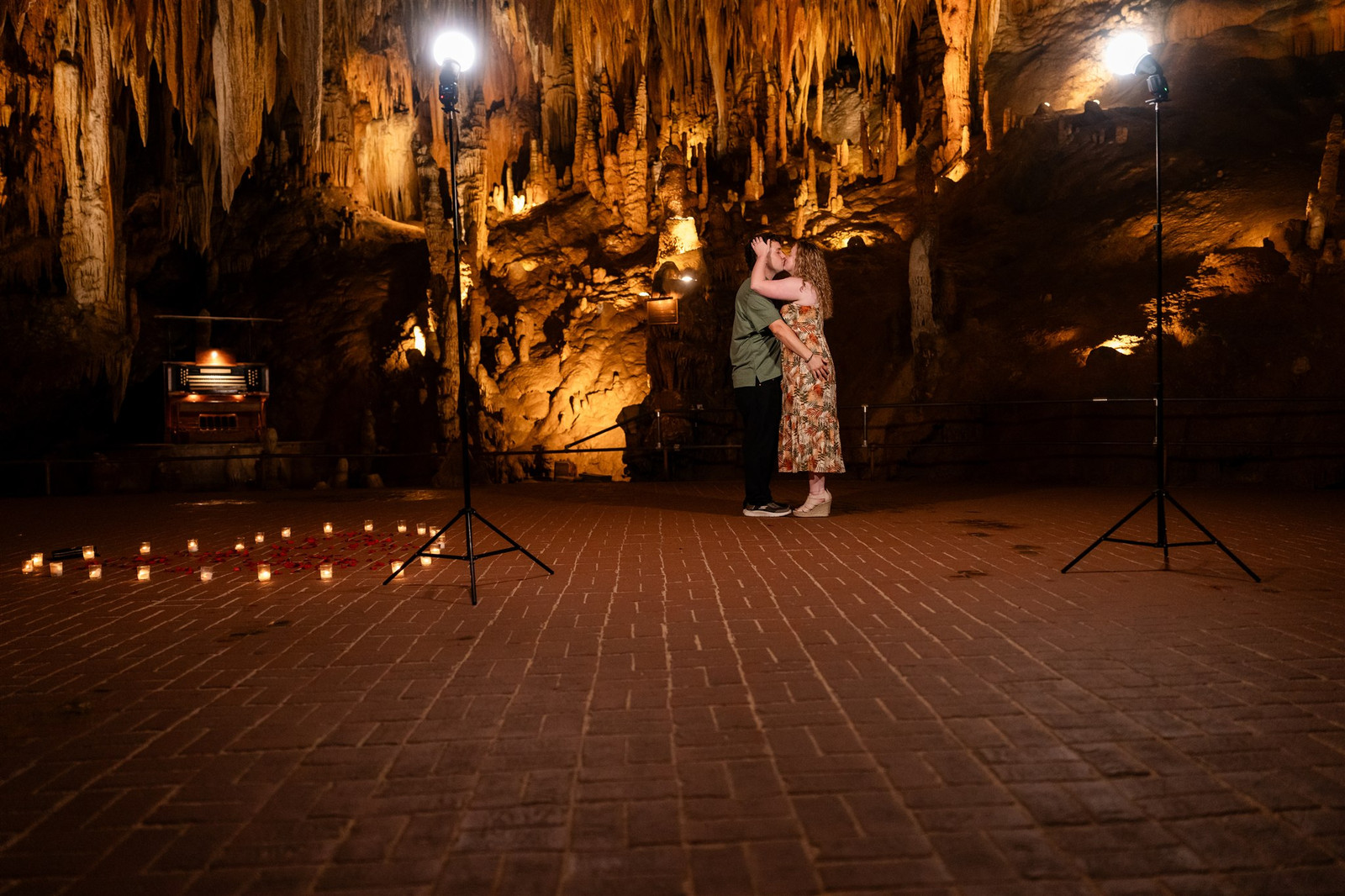 Couple kissing in Luray Caverns Cathedral Room, candles and spotlights.