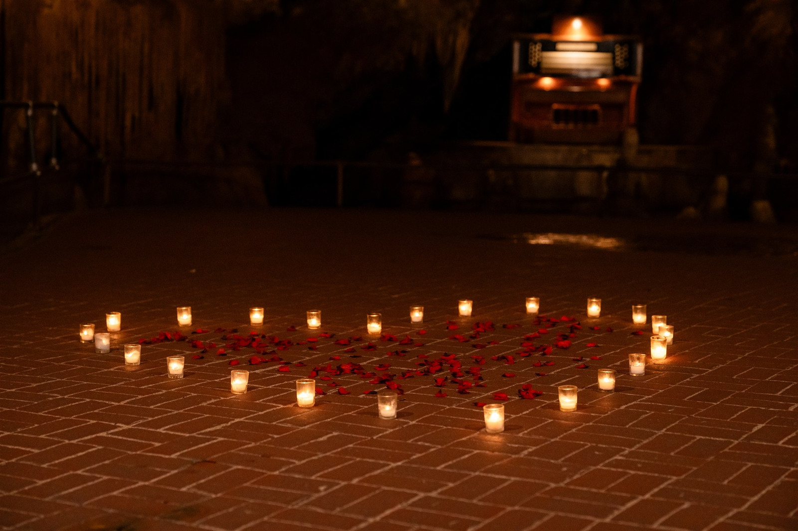 Romantic proposal setup at Luray Caverns: candles and rose petals in a heart shape.