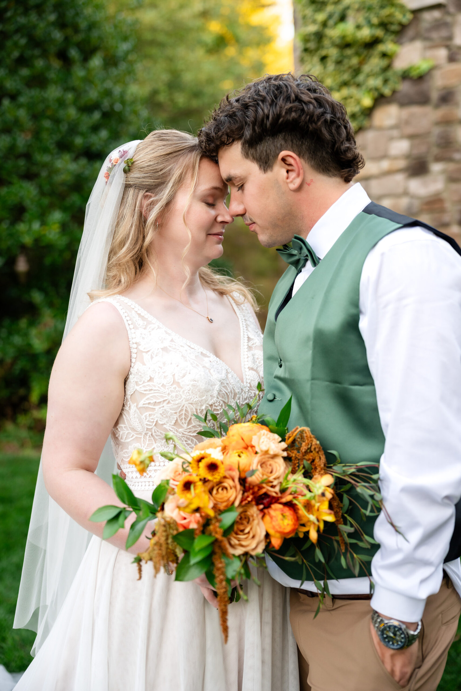 Bride and groom forehead to forehead, holding a colorful bouquet