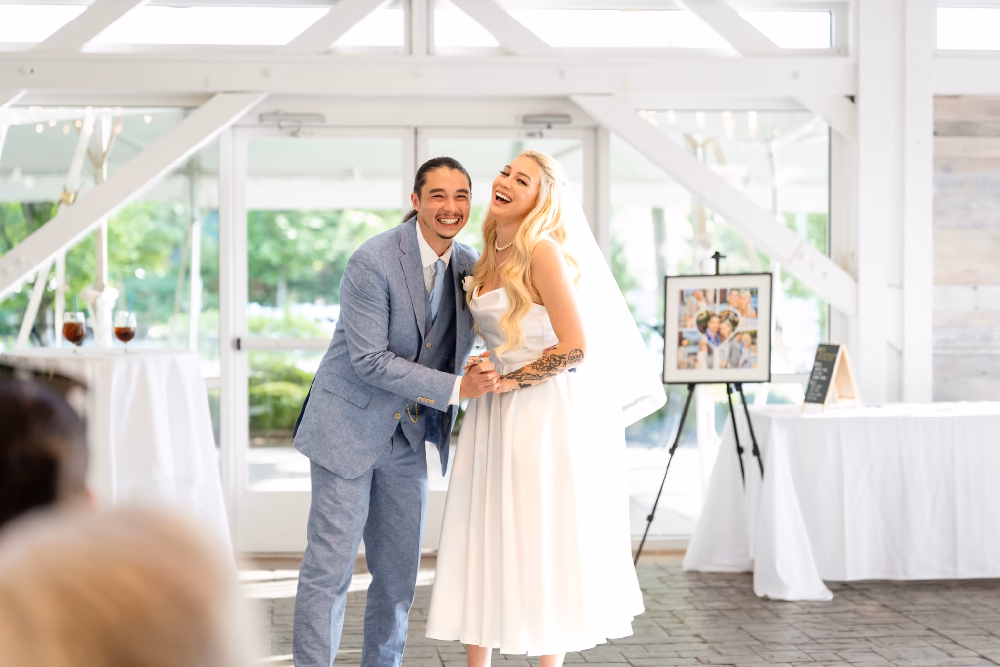 Joyful bride and groom laughing during their wedding reception.